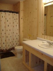 Cabin Bathroom with tub/shower combination.  This bathroom is located across from the Sunroom at the South End of the cabin.  The 2nd Bathroom is located off of the Dining area at the North end of the Cabin.  