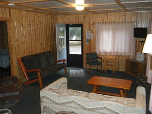 Cabin 1 Living Room includes a log couch, a hide-a-bed couch, living room chairs and an antique chair that started its life onboard a train!  High Definition TV with DVD player in the NorthWest Corner