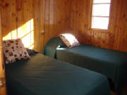 Two twin beds in this bedroom.  The other side of the bedroom includes a built in dresser and closet.