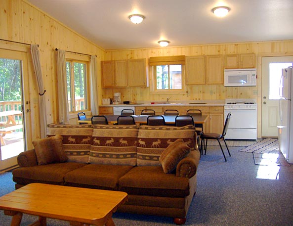 Large Main area with Living room, Dining area and Kitchen combined.  The french doors to the left of the picture lead to the deck.  The hallway to the right of the picture lead to the bathrooms and bedrooms.  The entry door off of the kitchen is ramped & leads to the parking area. 