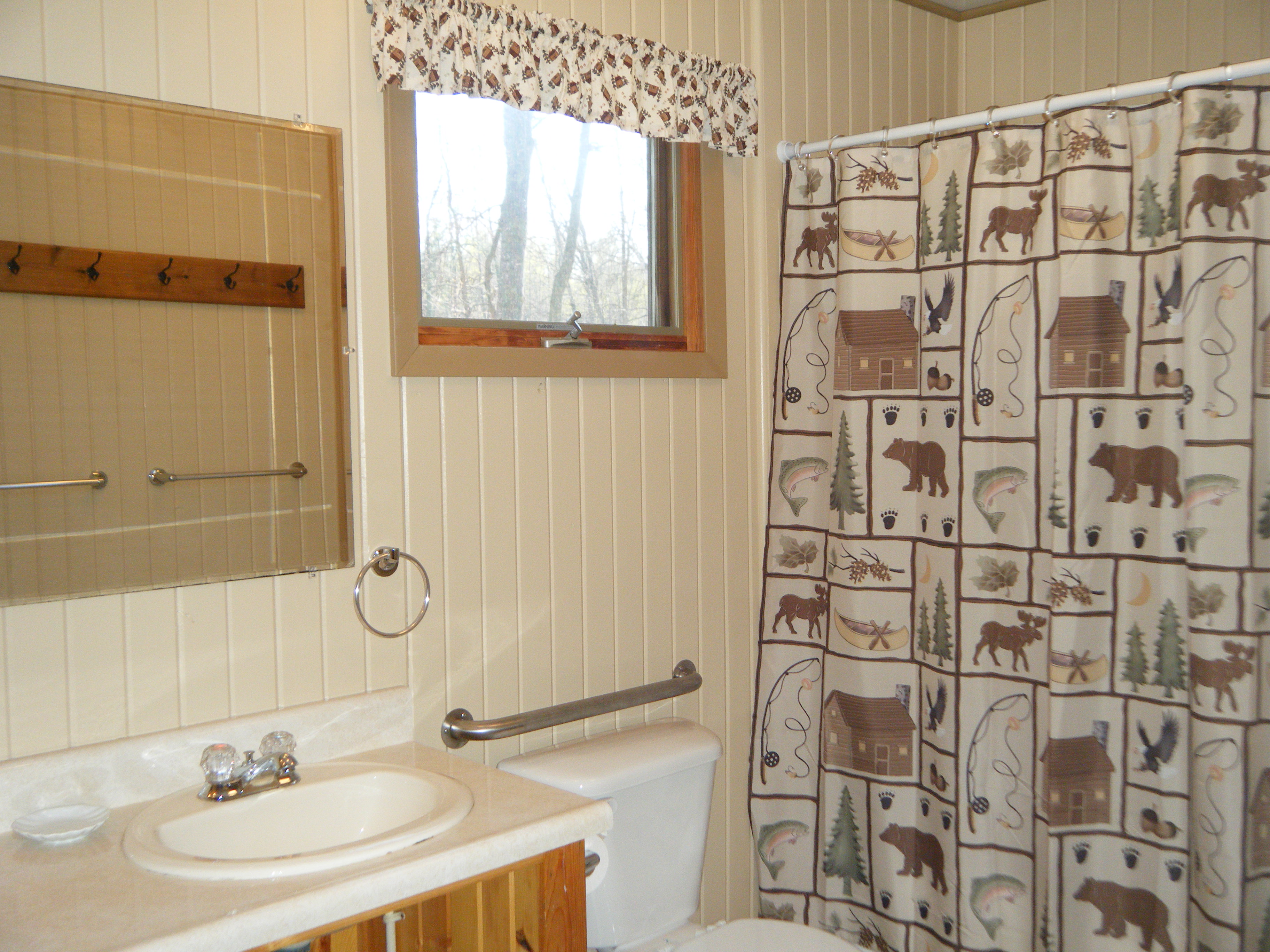 Cabin #15's main bathroom with tub/shower combination & decorated in "Up North' theme.  2nd bathroom is located off of the dining area.