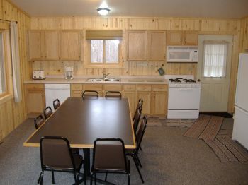 Cabin #17 kitchen fully stocked with dishes, pots/pans, and full size appliances plus a Microwave, dishwasher, & coffee pot.  Directly to the left of the dining table are french doors leading out to the deck.   