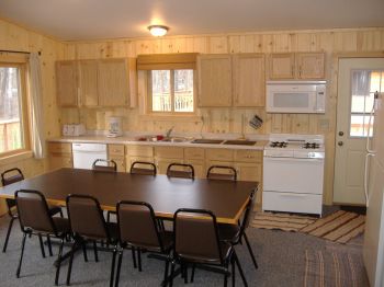 Cabin #18 kitchen fully stocked with dishes, pots/pans, and full size appliances plus a Microwave, dishwasher, & coffee pot.  Directly to the left of the dining table are french doors leading out to the deck.