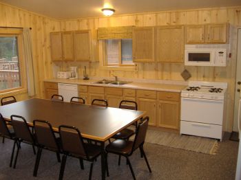 Cabin #19 kitchen fully stocked with dishes, pots/pans, and full size appliances plus a Microwave, dishwasher, & coffee pot.  Directly to the left of the dining table are french doors leading out to the deck.