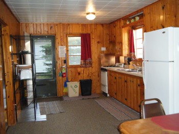 Cabin 8 kitchen is full stocked with pots/pans, dishes, silverware & full size appliances.  Kitchen leads into Dining area.