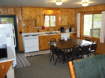 Cabin #15 kitchen fully stocked with dishes, pots/pans, and full size appliances plus a Microwave, dishwasher, & coffee pot. 