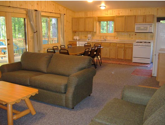 Large Main area with Living room, Dining area and Kitchen combined.  The french doors to the left of the picture lead to the deck.  The hallway to the right of the picture lead to the bathrooms and bedrooms.  The entry door off of the kitchen is ramped & leads to the parking area.   